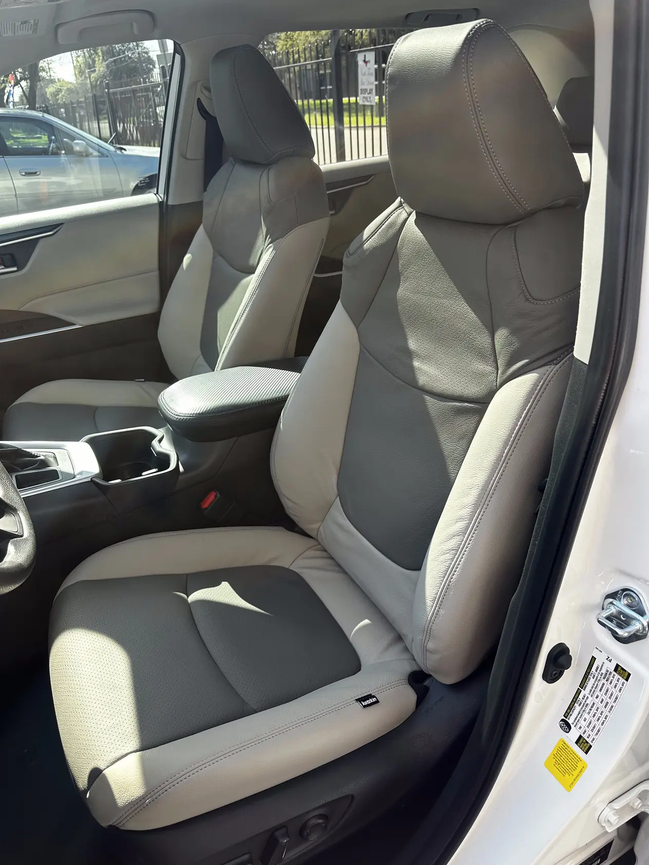 Two-tone gray and white Katzkin leather front seats installed in a vehicle interior